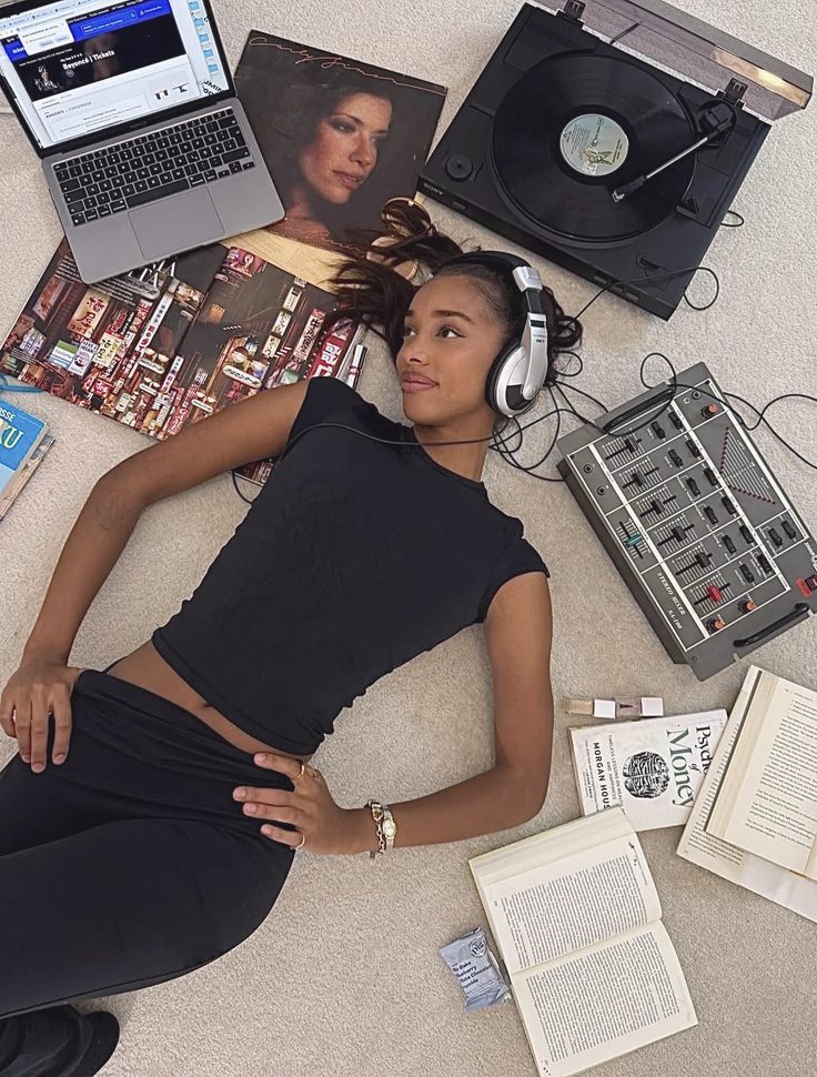 A woman surrounded by a laptop, records and books