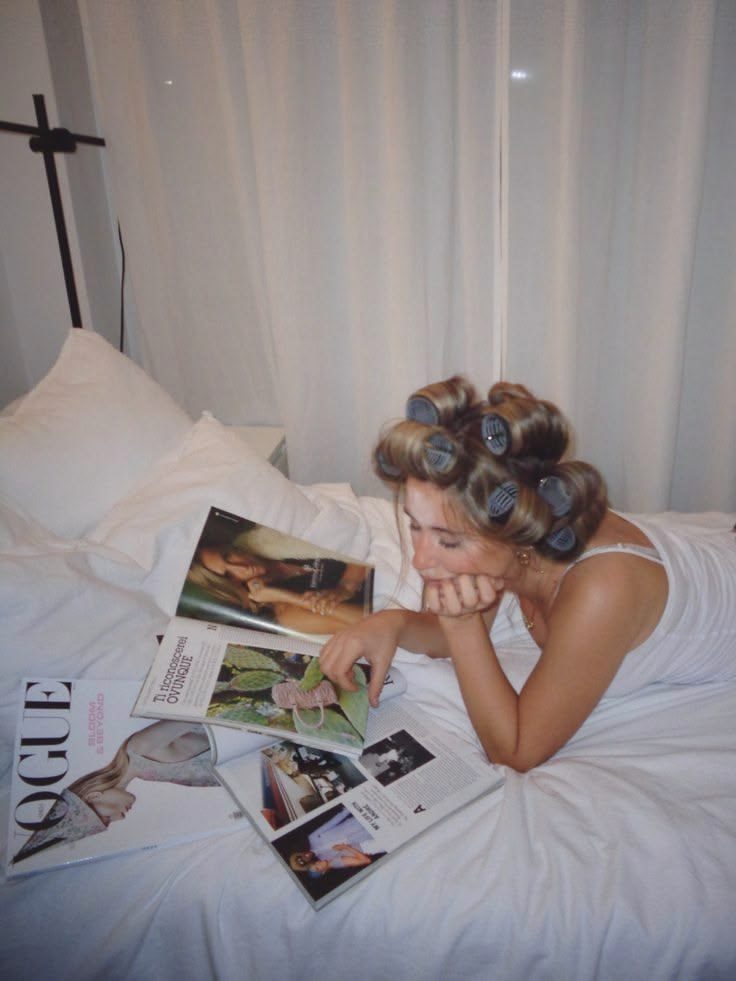 A woman reading magazines in bed